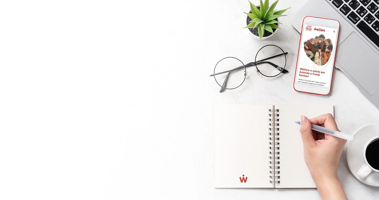 Scrivania con blocco note Welion, occhiali e cellulare su sito Welion