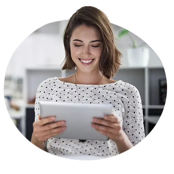 Donna sorridente mentre guarda un tablet, immagine a supporto dei servizi di prevenzione e benessere.